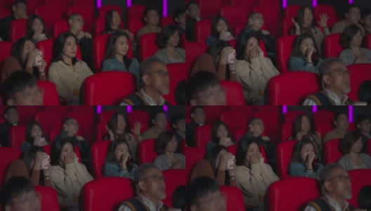 一群亚洲华人在电影院看恐怖的恐怖片高清在线视频素材下载