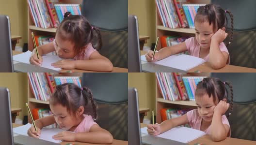 可爱的小女孩在家在线学习数学作业，在冠状病毒爆发期间保持社交距离。网络教育或家庭教育的概念。高清在线视频素材下载