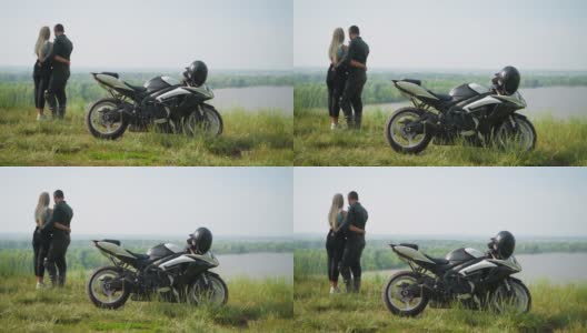 摩托车手和女友站在湖边的小山上高清在线视频素材下载
