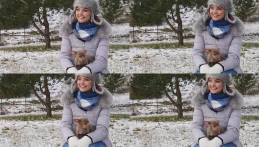 冬天，一个女人和她的小狗在外面玩耍高清在线视频素材下载