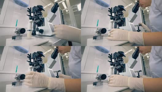 生化实验室的科学家用显微镜工作。4 k。高清在线视频素材下载