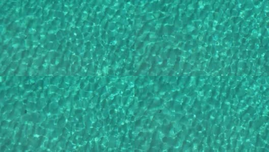 鸟瞰图的绿松石海在晴朗的日子。俯视图的小波浪在蓝色清澈的海水表面高清在线视频素材下载