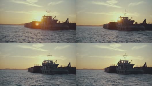 日落背景中一艘驳船的剪影。水路货物运输。美丽的景观象征着货物运输到买家高清在线视频素材下载