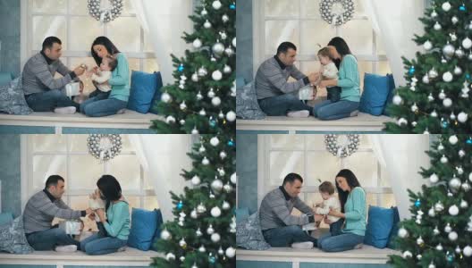 美丽的圣诞节快乐的家庭和小女孩坐在窗台上编织毛衣高清在线视频素材下载