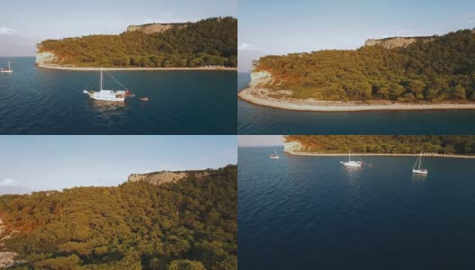 鸟瞰图的游泳船在海湾与德普蓝色的水。海上日落，4K超高清拍摄高清在线视频素材下载