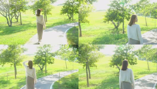 4K年轻的亚洲女人在公园里漫步高清在线视频素材下载