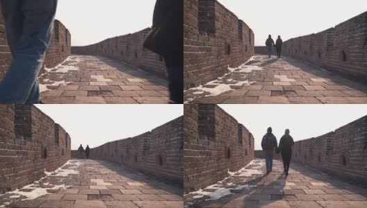 一对夫妇一起探索中国的长城，低镜头在宽阔的通道的石头路面上。冬天，游客们手牵手下来，欣赏空荡荡的慕田峪景区高清在线视频素材下载