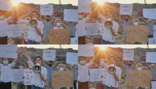 在亚洲的一个巨大的垃圾填埋场上，亚洲领袖女性用扩音器高喊，她们举着环保运动活动家为自然而战的海报。志愿服务、慈善、清洁、生态高清在线视频素材下载