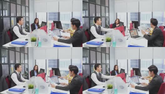 一群亚洲年轻人在办公室开会。男人和女人有交流头脑风暴和共同工作的项目作为团队。现代同事的企业高清在线视频素材下载
