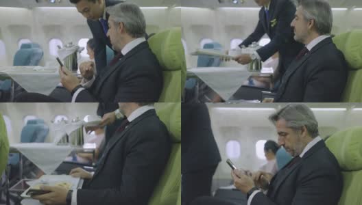 空姐在飞机上为男性商人提供食物高清在线视频素材下载