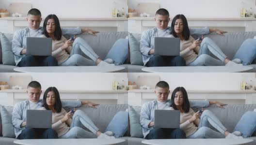 不满的亚洲夫妇在家里使用笔记本电脑和信用卡高清在线视频素材下载