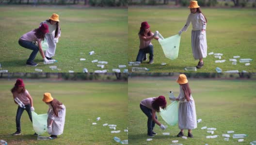 女孩和朋友帮助清理公园，捡起或垃圾收集地面上的垃圾高清在线视频素材下载