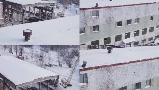 在大雪纷飞的冬天，一架无人机在旧的金属加工车间里飞行。高清在线视频素材下载