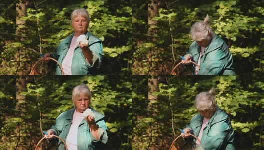 一位上了年纪的妇女在森林里展示珊瑚蘑菇高清在线视频素材下载