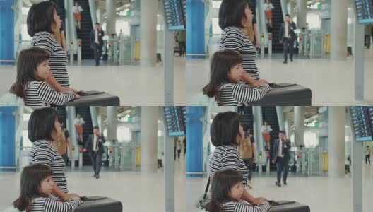 亚洲母亲和她的女儿在机场寻找航班时间高清在线视频素材下载