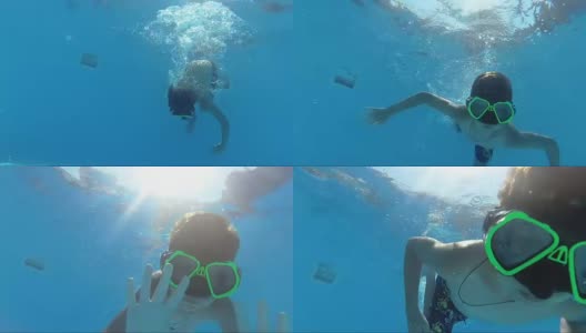 男孩在游泳池里潜水，看着相机，水下拍摄，阳光高清在线视频素材下载