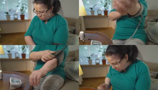 一位上了年纪的妇女在家测量血压高清在线视频素材下载