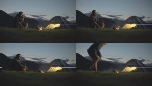 年轻人走进去，露营在户外的山在晚上用营火温暖他和走开-高清视频录像高清在线视频素材下载