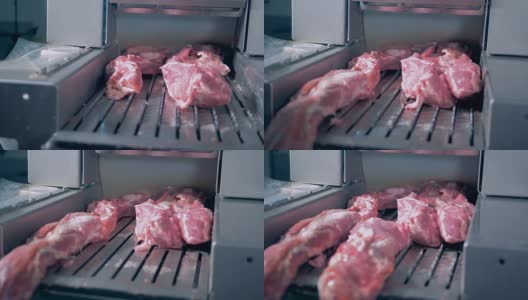 一个工人把肉放到绞肉机上。高清在线视频素材下载