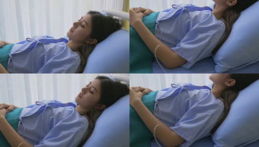 在医院使用生理盐水容量输注泵的病人在检查床上睡觉。高清在线视频素材下载
