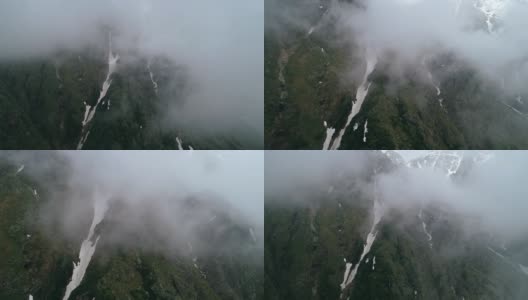 在高山环绕的云中美丽的飞行。高清在线视频素材下载