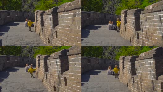 慢动作镜头拍摄的中国长城，上升的一边的山。一位年轻妇女和她的小儿子在长城的楼梯上休息高清在线视频素材下载