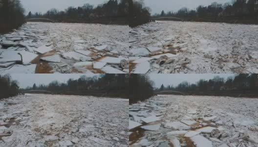 巨大的冰块漂流在拉脱维亚的食人河。空中龙拍摄雪城日。春天这条河上的交通堵塞。一大群移动的冰块高清在线视频素材下载