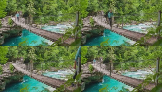 一个女人正穿过山溪上的木吊桥高清在线视频素材下载