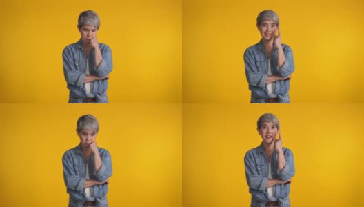 一个中年的亚洲女人孤独地站在黄色的背景下高清在线视频素材下载