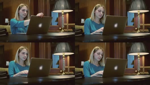 商务女性打开笔记本电脑工作的桌子上有台灯高清在线视频素材下载