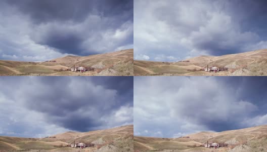多云的天空上方的房子在丘陵山谷高清在线视频素材下载