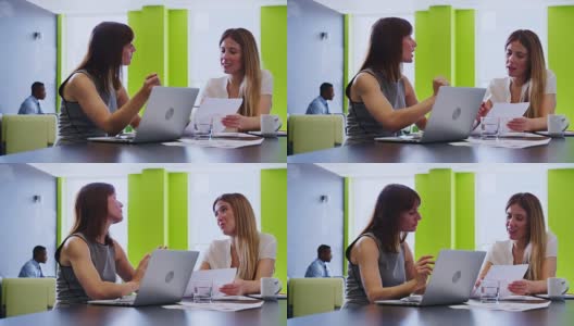 两位年轻的女同事在一次非正式的工作会议上交谈高清在线视频素材下载