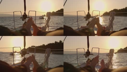 光脚的情侣触摸脚趾，在宁静的日落帆船上放松，实时高清在线视频素材下载