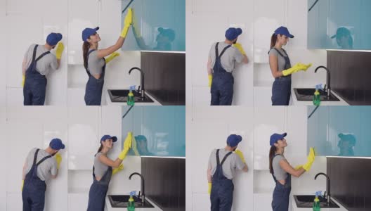 漂亮年轻的清洁公司工人戴着橡胶手套擦拭高科技厨房高清在线视频素材下载