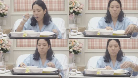 亚洲妇女病人在医院的床上吃饭高清在线视频素材下载