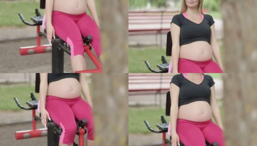 一位孕妇在户外骑着健身自行车训练高清在线视频素材下载