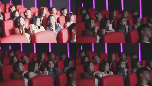 亚洲的中国女人在电影院看恐怖的惊悚电影，和其他观众一起看高清在线视频素材下载