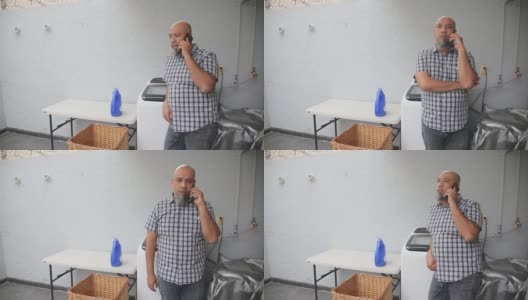 一个男人一边在家洗衣服，一边打电话高清在线视频素材下载