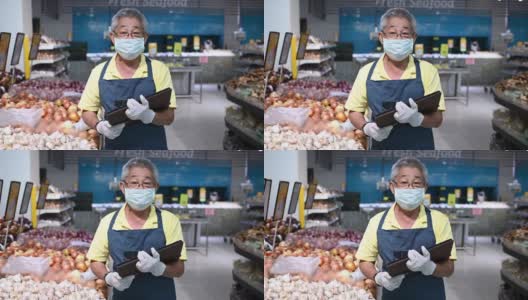 一名亚洲华人高级男子，超市店主，零售助理，戴着口罩高清在线视频素材下载