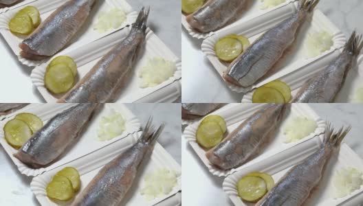 一排新鲜的荷兰生鲱鱼放在一次性盘子靠近高清在线视频素材下载