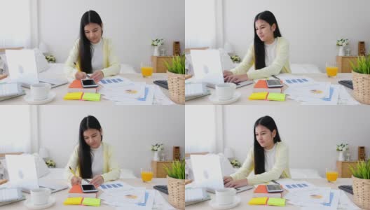 亚洲女性自由职业者打字工作与笔记本电脑在桌子上在家里的卧室。在家工作的概念。在家工作概念高清在线视频素材下载