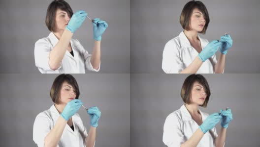 年轻女医生戴手套，拿着注射器，准备注射隔离在灰色背景。医疗保健的概念。在4 k拍摄高清在线视频素材下载