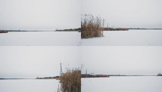 在被芦苇覆盖的雪景覆盖的冰冻湖面上的驳船高清在线视频素材下载