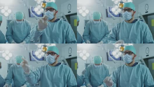手术室外科医生在手术中使用增强现实技术的手势。在后台助理和护士使用真正的设备工作。高清在线视频素材下载