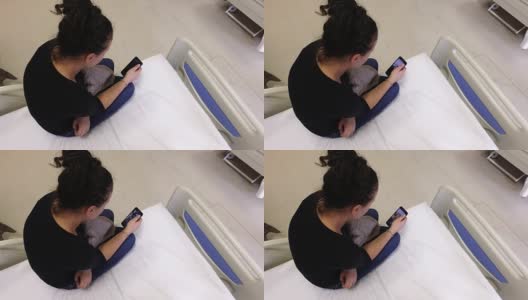 美丽的女病人在医院病床上使用智能手机。手术后等待出院高清在线视频素材下载