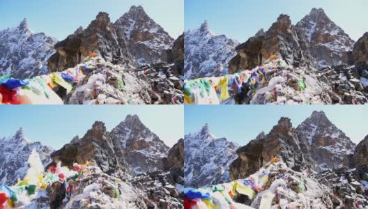 在尼泊尔喜马拉雅山脉中，珠穆朗玛峰地区的莲若拉山口(Renjo La Pass)顶上，五颜六色的佛教经幡在强风中飘扬。高清在线视频素材下载
