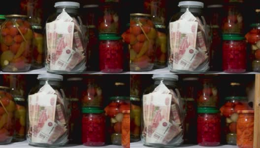 食品柜架子上放着一罐钱，还有蔬菜罐头和其他用品高清在线视频素材下载