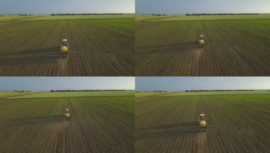 农用拖拉机用黄色大喷雾器喷洒小绿芽和除草剂在广阔的田野上，在春天鸟瞰高清在线视频素材下载