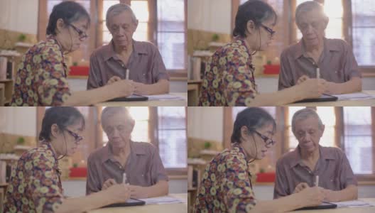 亚洲老男人和女人使用手机扫描和支付家庭财务账单高清在线视频素材下载