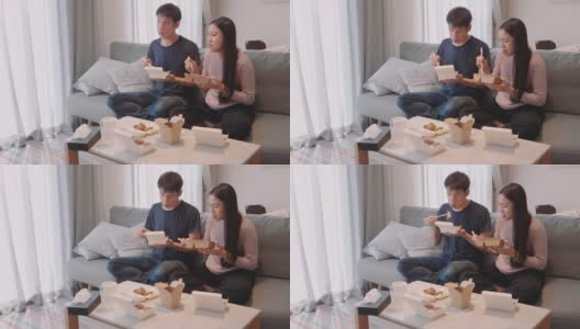 一对夫妇在沙发上吃着送过来的午餐高清在线视频素材下载